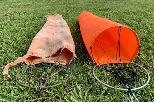 Faded orange windsock next to new international orange Safeguard windsock